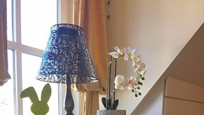 A room with a window, a lamp, a decorative bunny, and a potted orchid. - Hotel Prinz Albrecht (Neuzelle)