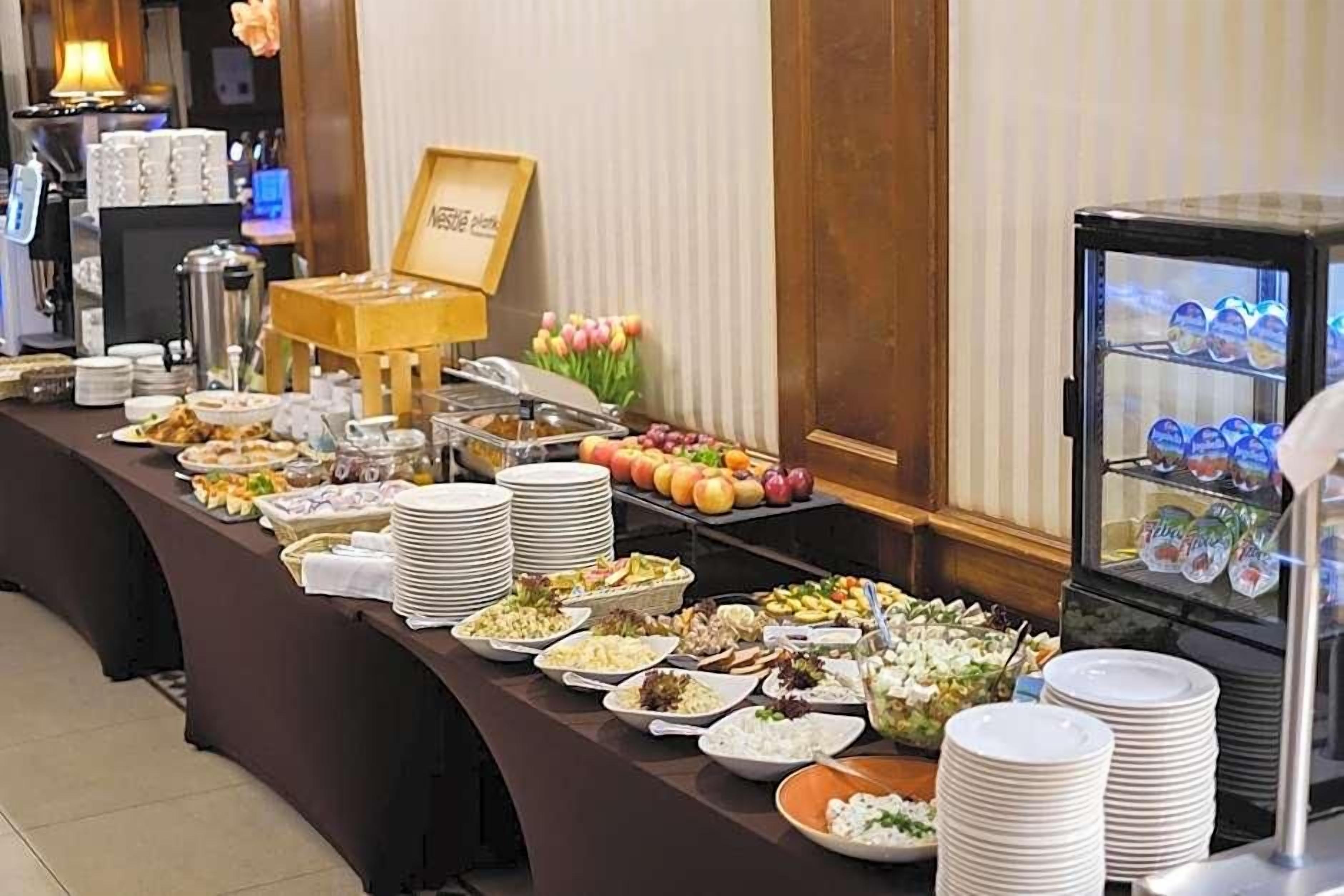 A buffet setup with various food items and a refrigerator with beverages.