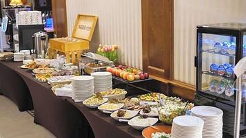 A buffet setup with various food items and a refrigerator with beverages.