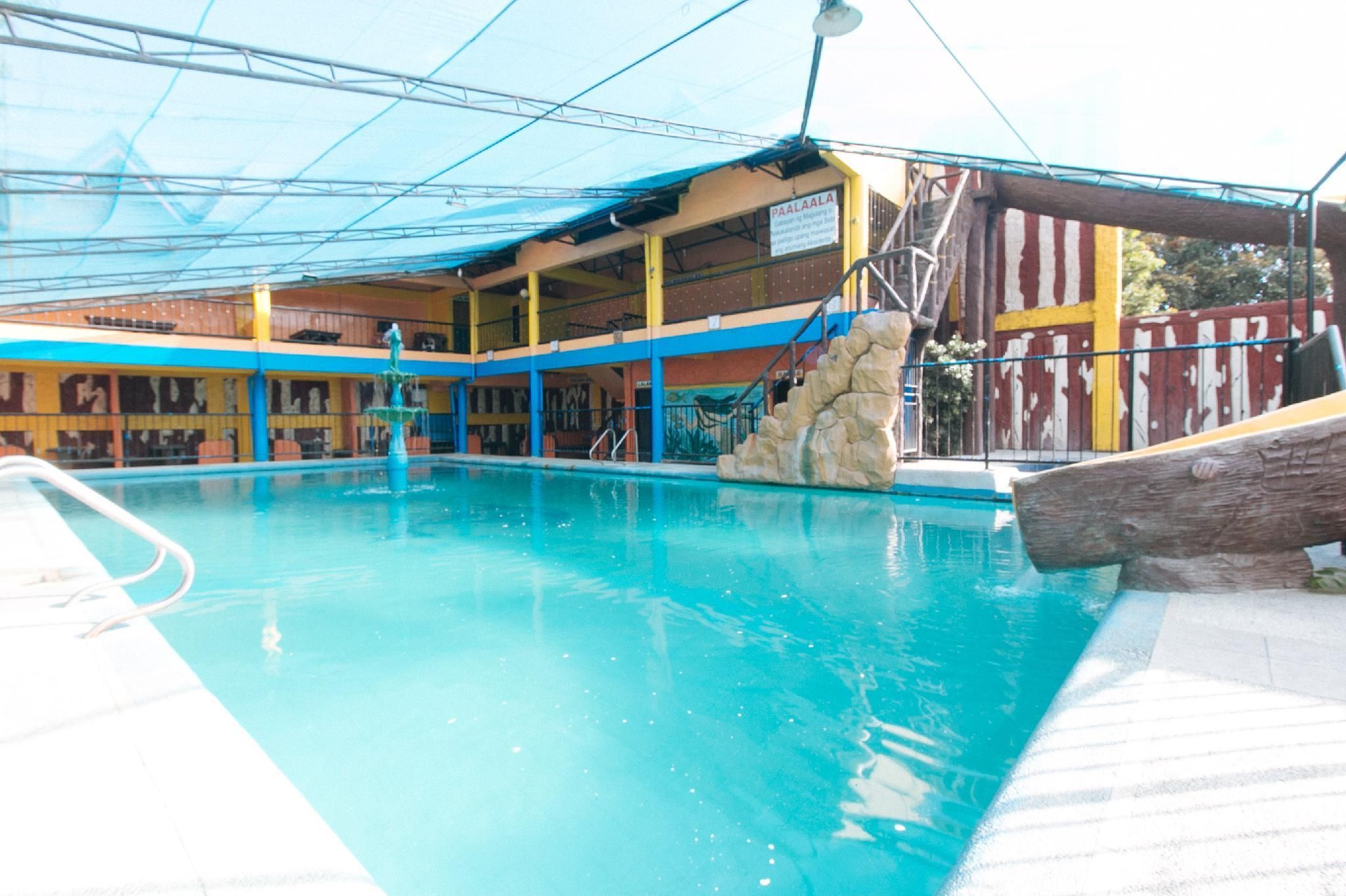 A swimming pool with a stone feature, a covered seating area, and a sign indicating 'PAALAALA.'