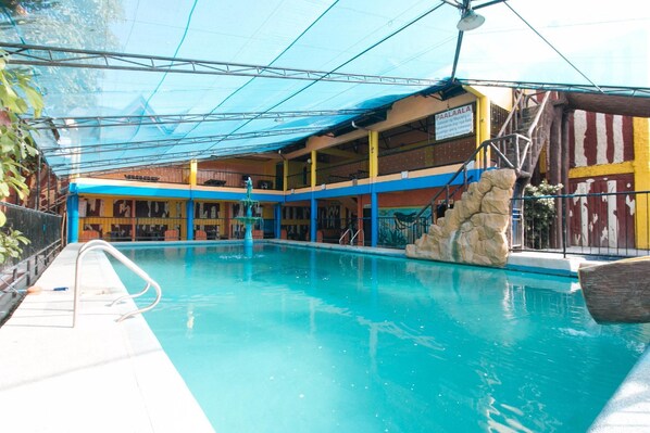 An indoor swimming pool with a covered area, a staircase, and a rock feature. - Alamaris Resort (Morong)