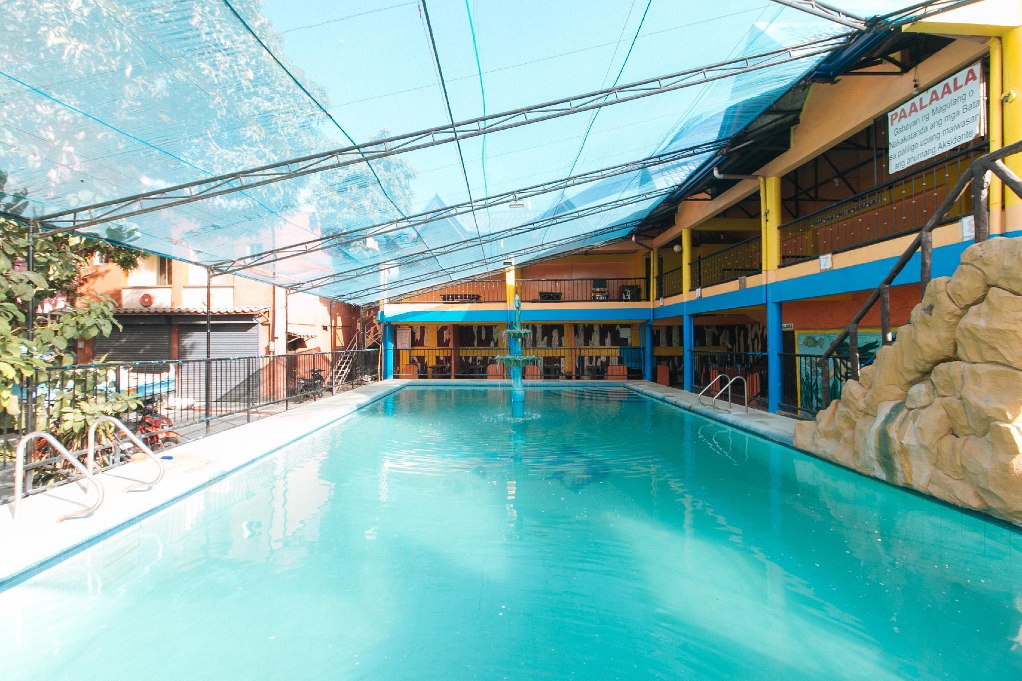 A swimming pool with a clear view of the surrounding buildings, including a signboard.