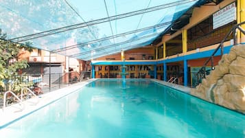 A swimming pool with a clear view of the surrounding buildings, including a signboard.