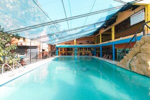 A swimming pool with a clear view of the surrounding buildings, including a signboard. - Alamaris Resort (Morong)