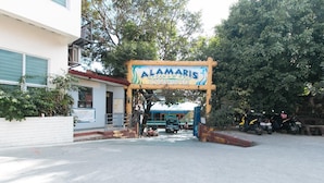A sign for Alamaris Resort, a building entrance, and parked motorcycles. - Alamaris Resort (Morong)