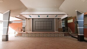 A spacious lobby with a tiled floor, a staircase with a handrail, and a large wall-mounted screen. - Alamaris Resort (Morong)