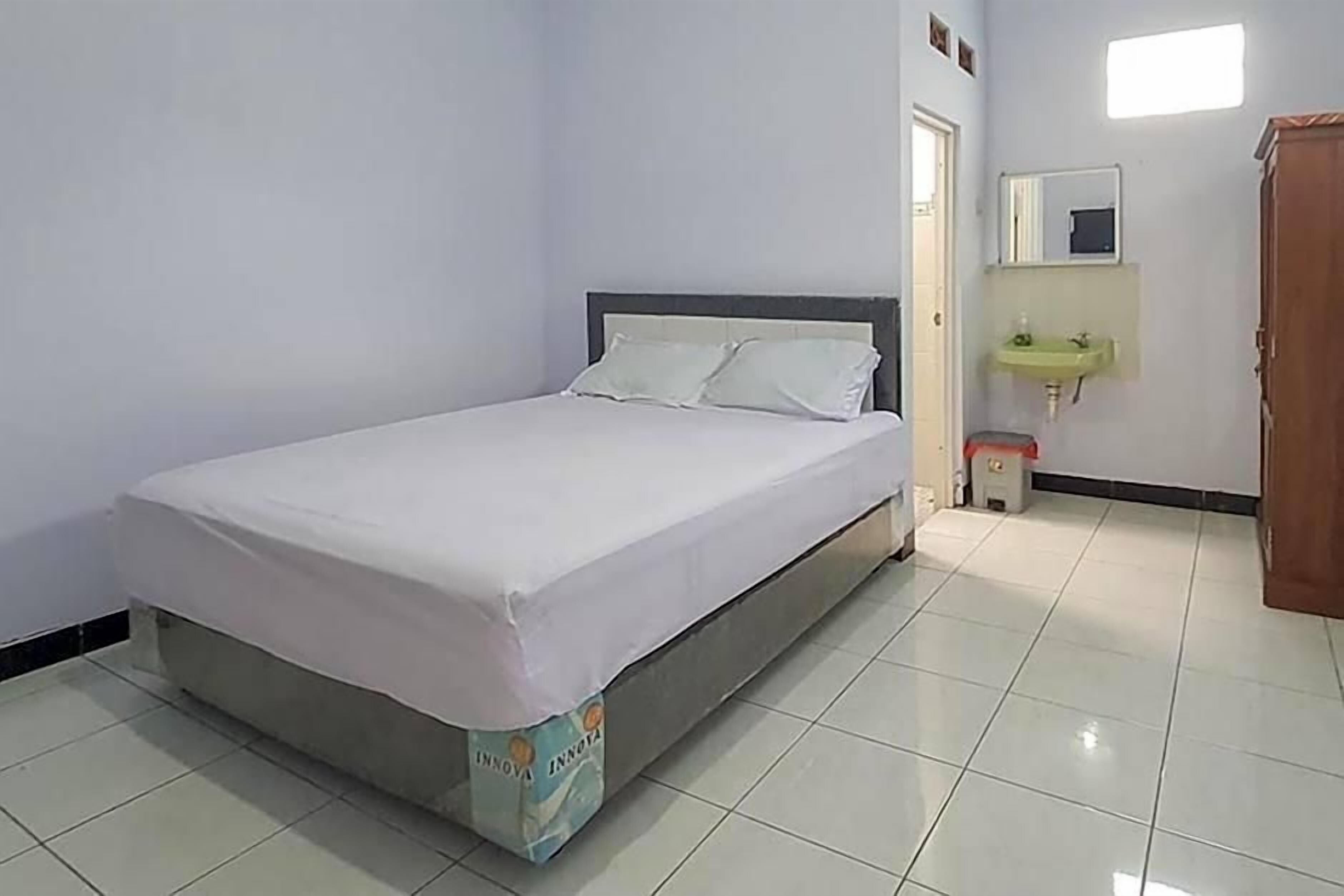 A room with a bed, a sink, and a mirror.