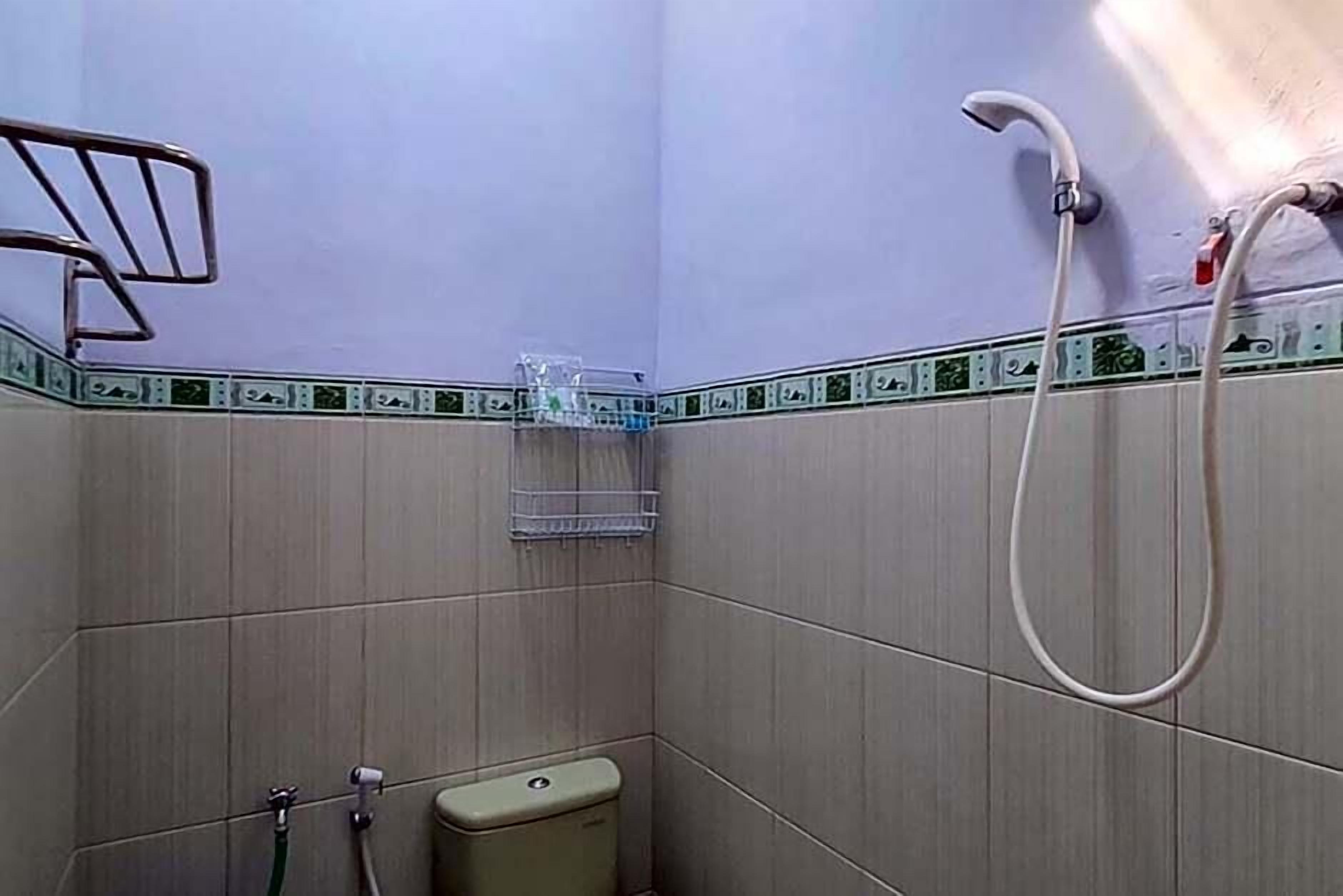 Ein kleines Badezimmer mit Dusche, Toilette und Handtuchhalter.