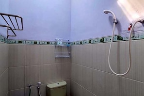 Ein kleines Badezimmer mit Dusche, Toilette und Handtuchhalter.