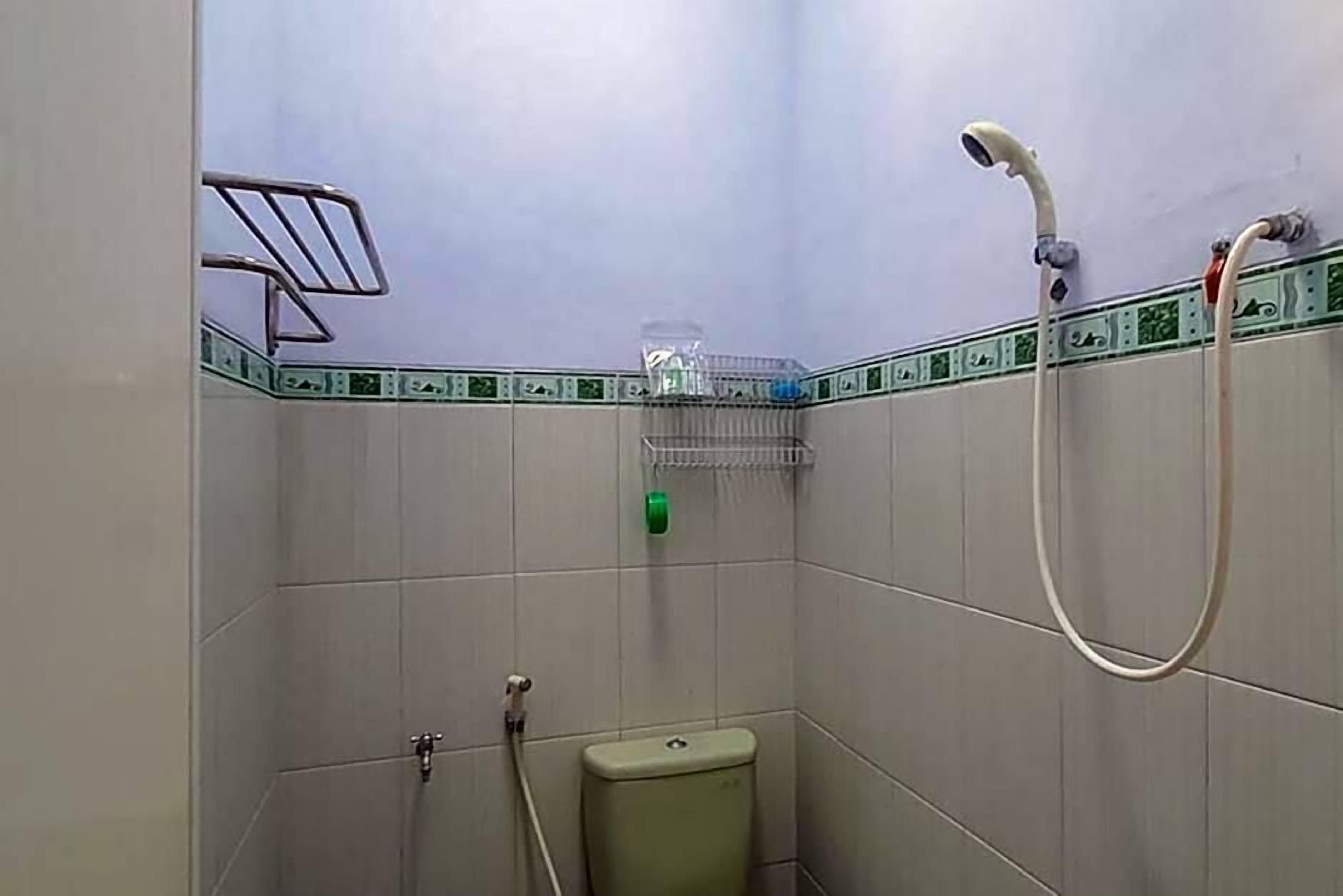 A small bathroom with a toilet, a shower, and a towel rack.