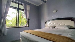 A bedroom with a bed, a window, and curtains.