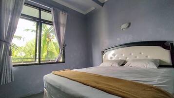 A bedroom with a bed, a window, and curtains.