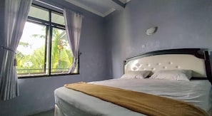 A bedroom with a bed, a window, and curtains.