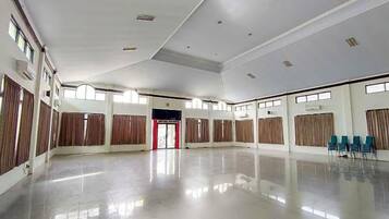 A spacious hall with a high ceiling, large windows, and a reflective floor.