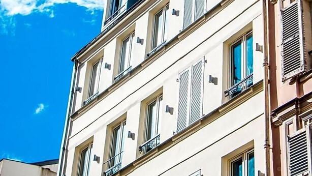 Un immeuble à plusieurs étages doté de balcons et de fenêtres.