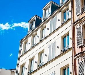 Un immeuble à plusieurs étages doté de balcons et de fenêtres.