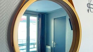 Un miroir rond avec un cadre doré, accroché au mur.