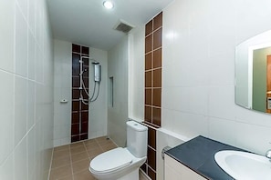 Un baño con inodoro, ducha y lavamanos.