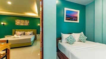 A bedroom with a bed, bedside tables, a nightstand, and a wall-mounted picture.