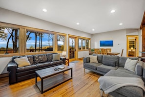A spacious living area with large windows, a fireplace, and a cozy seating arrangement. - Majestic Mtn Views Hot Tub Sauna Arcade Room (Penrose)