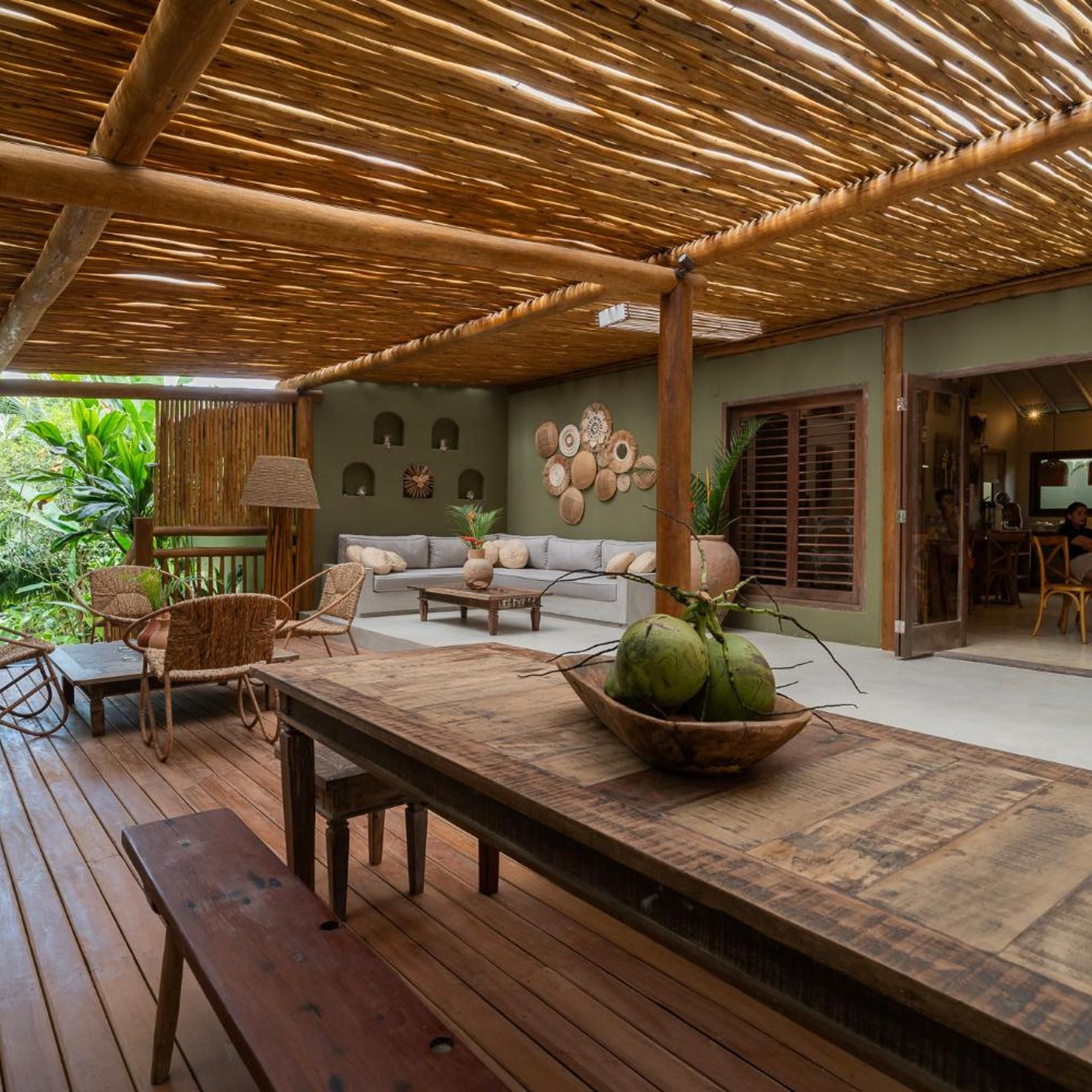 Uma área externa com mesa, cadeiras e sofá de madeira.
