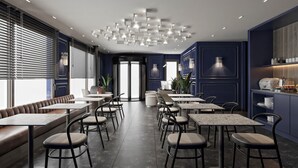 A modern restaurant with a central seating area, tables, and chairs arranged around it. - The Search Hotels Bosphorus (Istanbul)