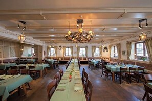 A spacious dining hall with long tables, chandeliers, and a central decorative piece. - Hotel Gasthof Alte Post Holzkirchen (Holzkirchen)