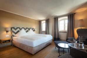 A hotel room with a bed, a small table with glasses, a chair, and a lamp. - Hotel Gasthof Alte Post Holzkirchen (Holzkirchen)