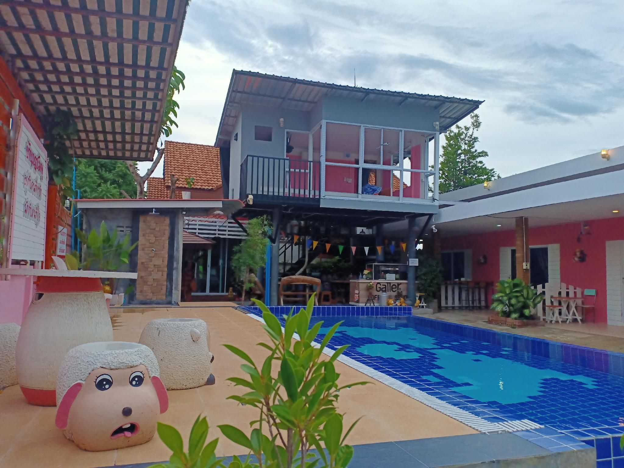 A pool area with a two-story building, a covered seating area, and a sign for a restaurant.