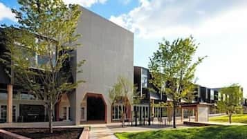 A modern building with a flat facade, a central entrance, and a small adjacent structure.