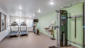 A fitness center with treadmills, an elliptical, and a weight machine. - Woodspring Suites Jacksonville Campfield Commons (Jacksonville)
