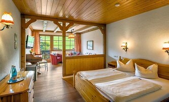 Ein Zimmer mit Holzwänden, einem Bett, einem Schreibtisch und einem Stuhl.