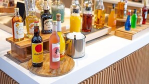 A bar area with various bottles of alcohol and a metal container. - Super Hotel Okayama Station Higashiguchi (Okayama)