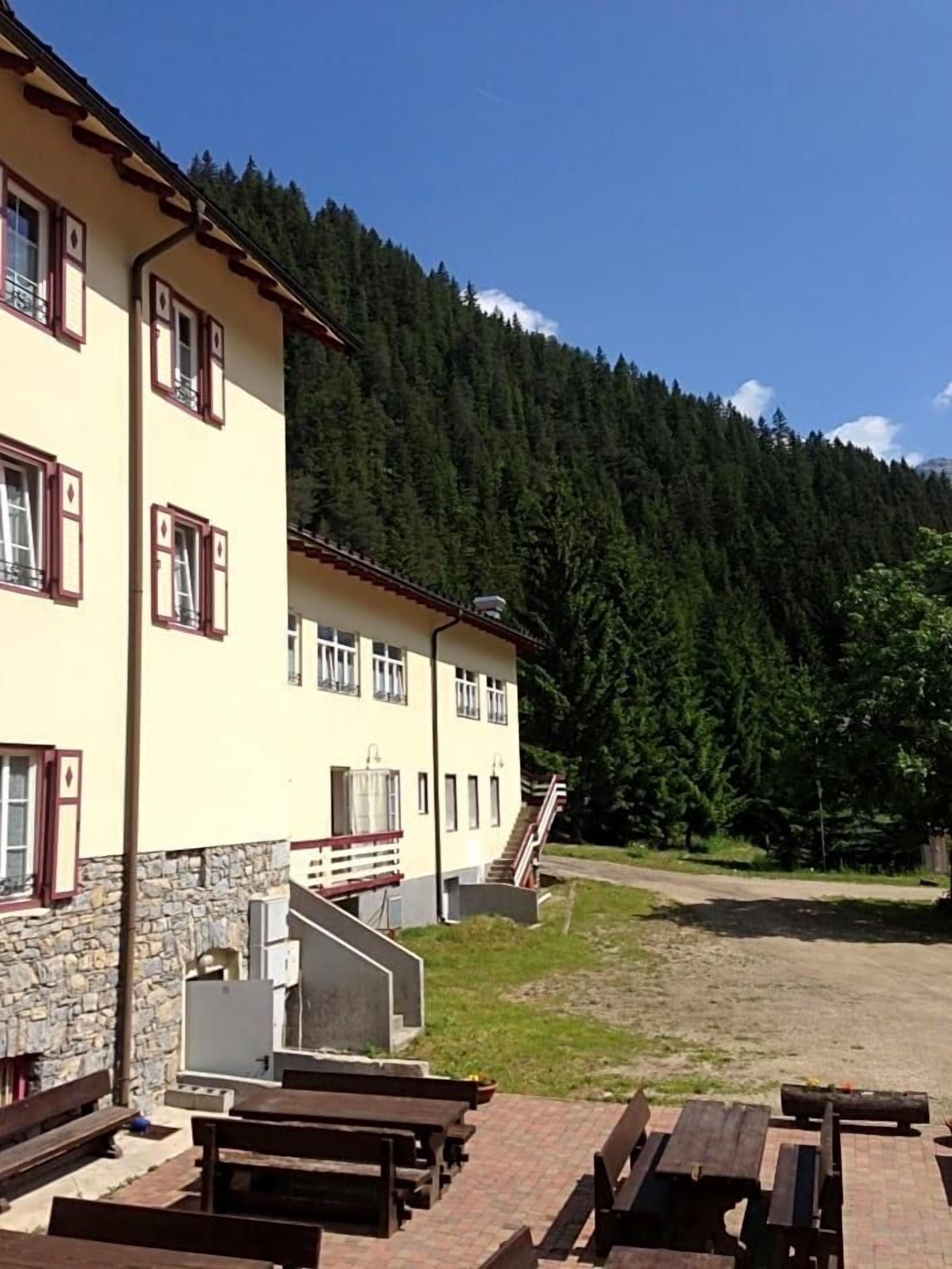 A building with multiple windows and a staircase leading to a second floor.