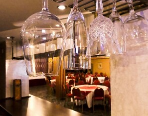 A restaurant interior with hanging glass chandeliers and tables set for dining. - Vienni (Orestiada)