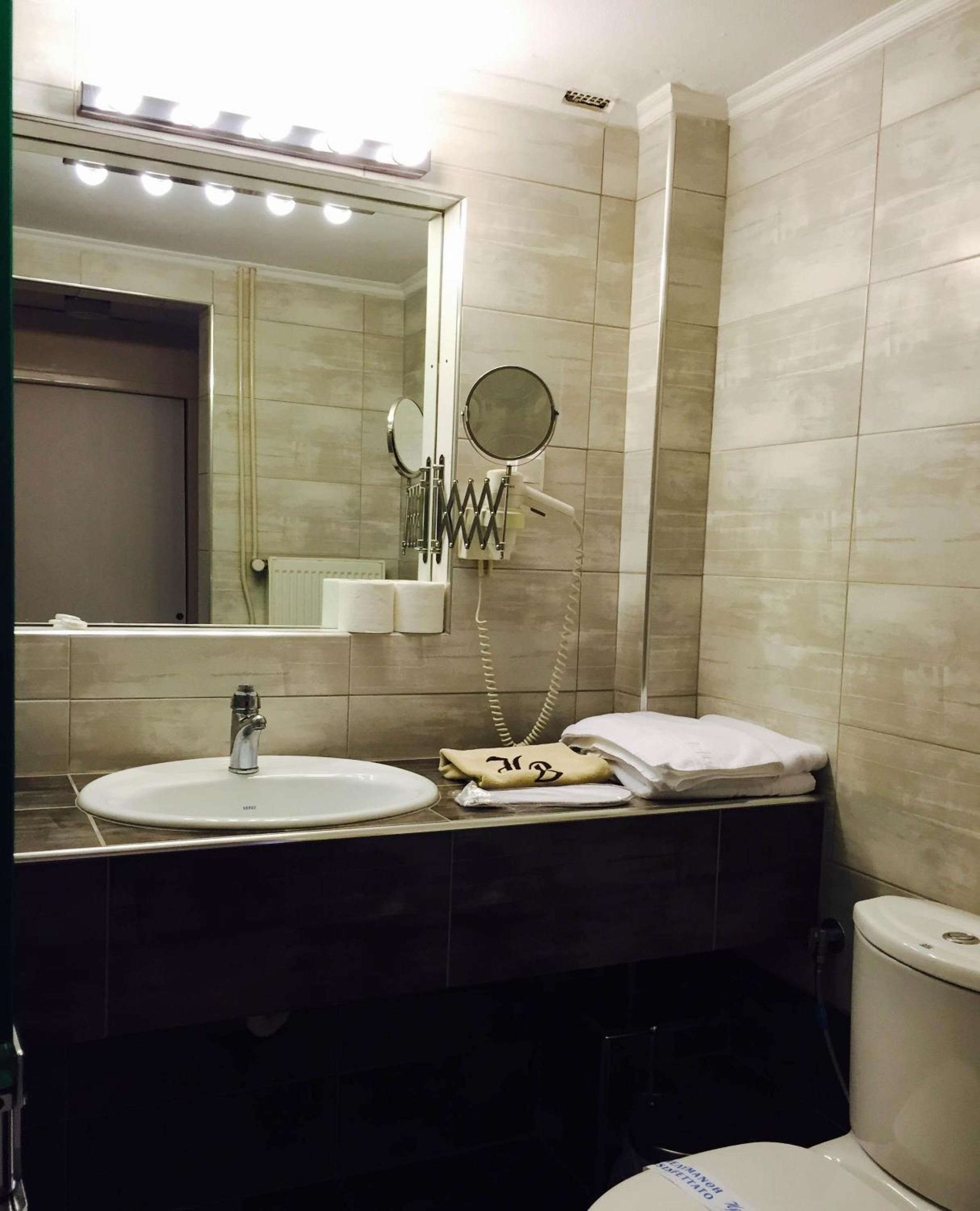 Ein Badezimmer mit Waschbecken, Spiegel und Toilette.
