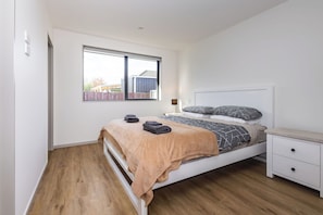 Ein Schlafzimmer mit einem Bett, einem Nachttisch und einem Fenster.
