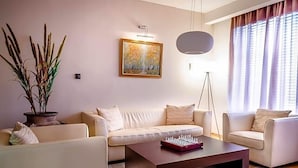 Una sala de estar con un sofá, una mesa de centro, un cuadro y una lámpara de pie.