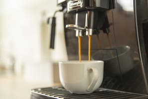 Máquina de café servindo café numa chávena.