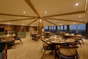 Un restaurante con suelo de madera, sillas de mimbre y mesas dispuestas para comer.