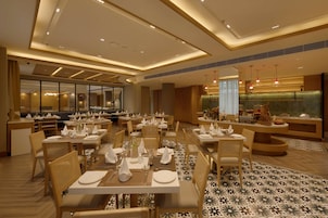A restaurant with multiple tables, chairs, and a bar area.