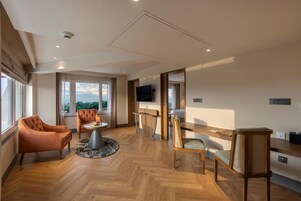 Una habitación amplia con un gran ventanal, un televisor de pantalla plana, una mesa de comedor de madera y una zona de estar confortable.