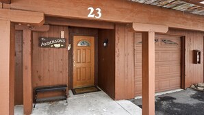 A wooden building with a number '23' above the entrance, a door with a sign reading 'Andersons', and a garage door. - Alpine Manor Retreat (Olympic Valley)