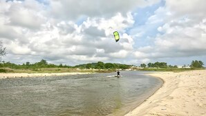A river with a sandy beach and a person kiteboarding. - D Ng A A Ng Hotel (Phu Quoc)