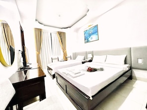 Quarto de hotel com uma cama grande, uma escrivaninha, uma cadeira, um espelho e um quadro na parede.