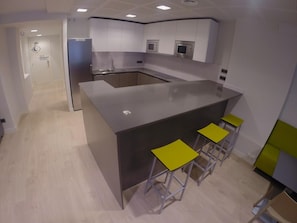 Une cuisine moderne dotée d’un îlot central, d’un évier et de tabourets de bar.