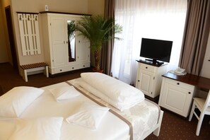 Una habitación de hotel con una cama, un escritorio, un televisor y un armario.