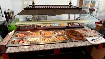 Un bufé con diversos alimentos y utensilios.
