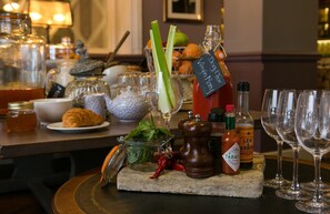 A bar setting with various condiments, a bottle of Dog & Fox Virgin Mary, and empty wine glasses. - Dog And Fox (London)