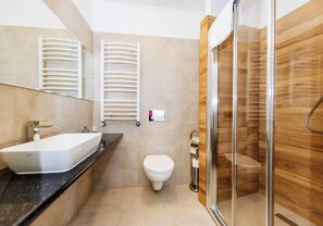 A modern bathroom with a large white sink, a toilet, and a glass-enclosed shower area. - Hotel Marczewski (Bielsko-Biala)
